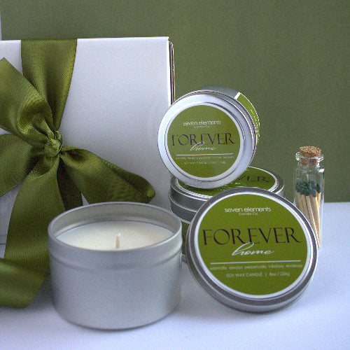 Candle and packaging with 'Forever Home' branding on a white surface.