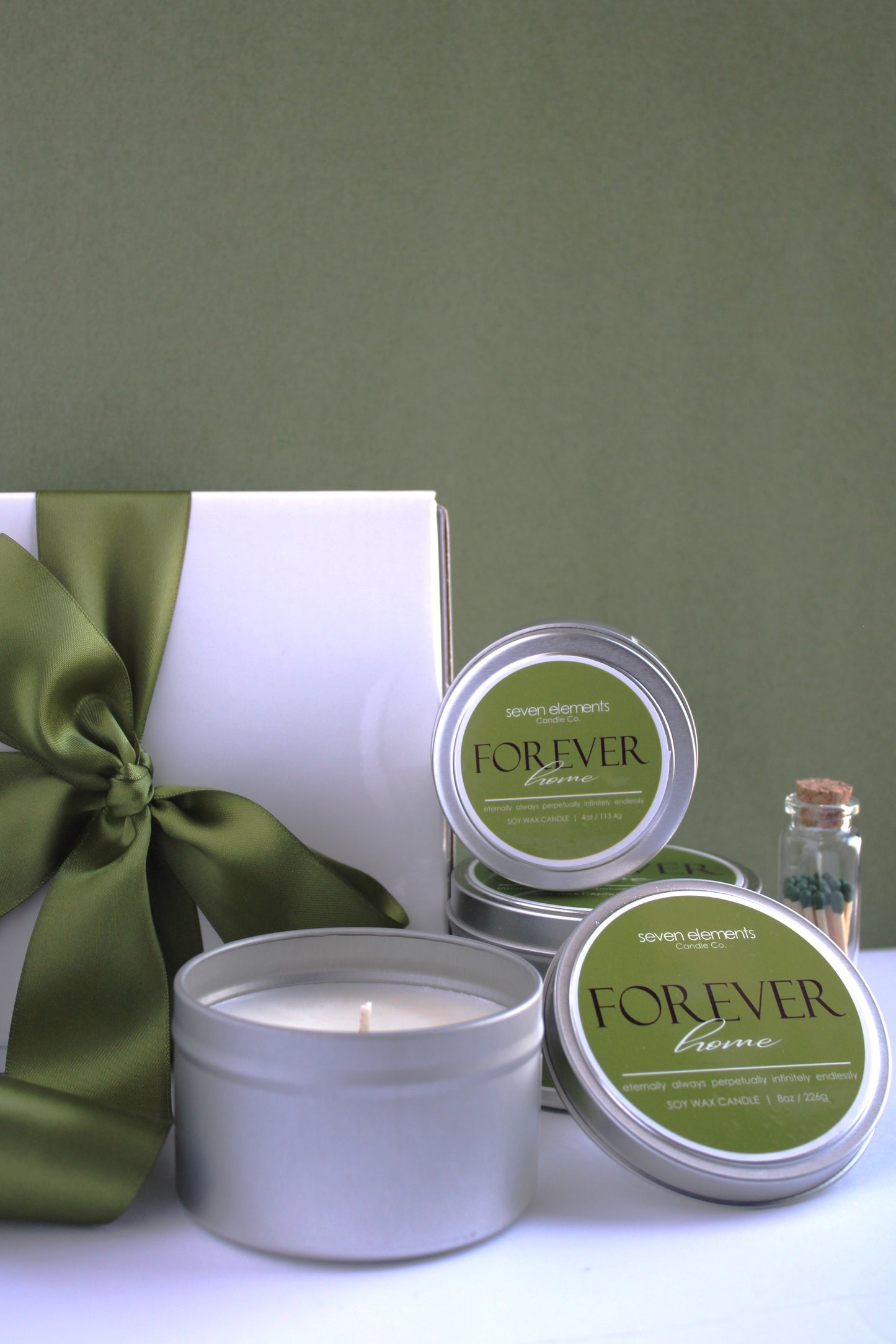 Candle and packaging with 'Forever' branding on a green background