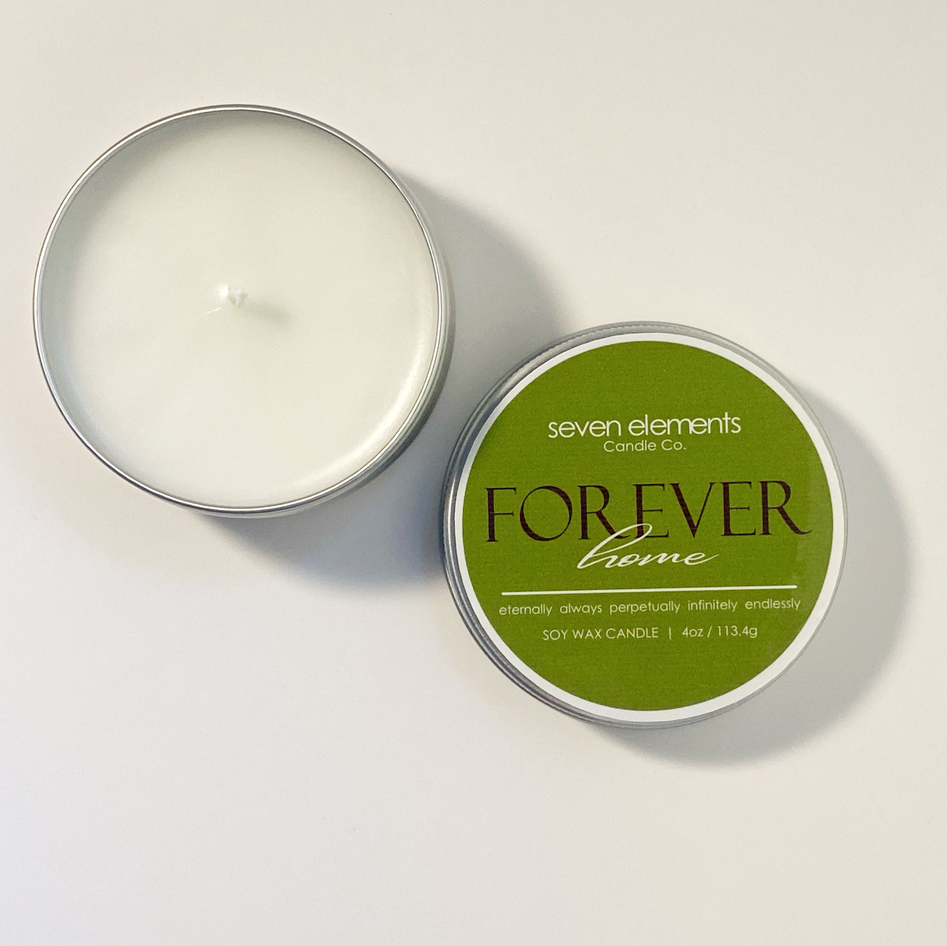 Candle in a tin with 'Seven Elements Candle Co' label on a light background