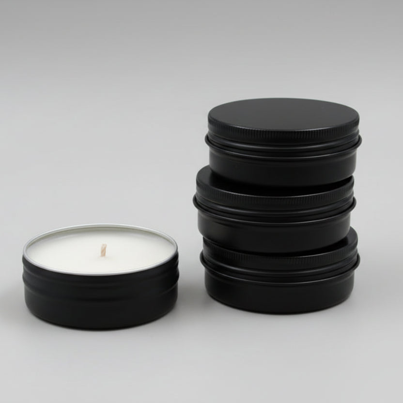 stack of small black candle tins and a single black candle tin