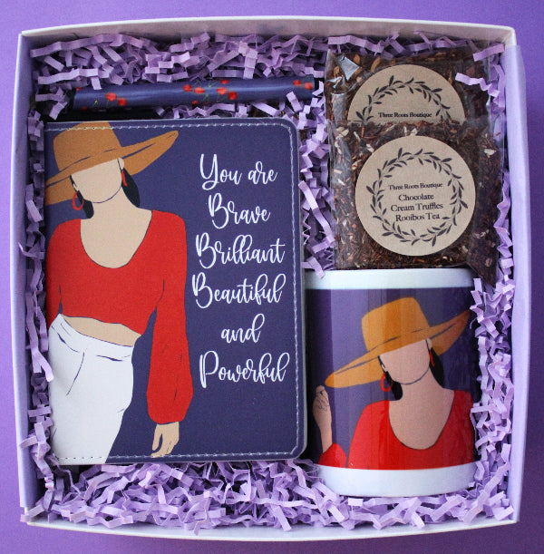 Gift set with mug, tea, and card in a box on a purple background