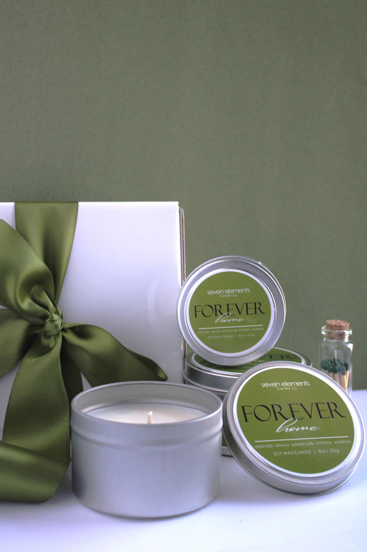 Candle and packaging with 'Forever' branding on a green background