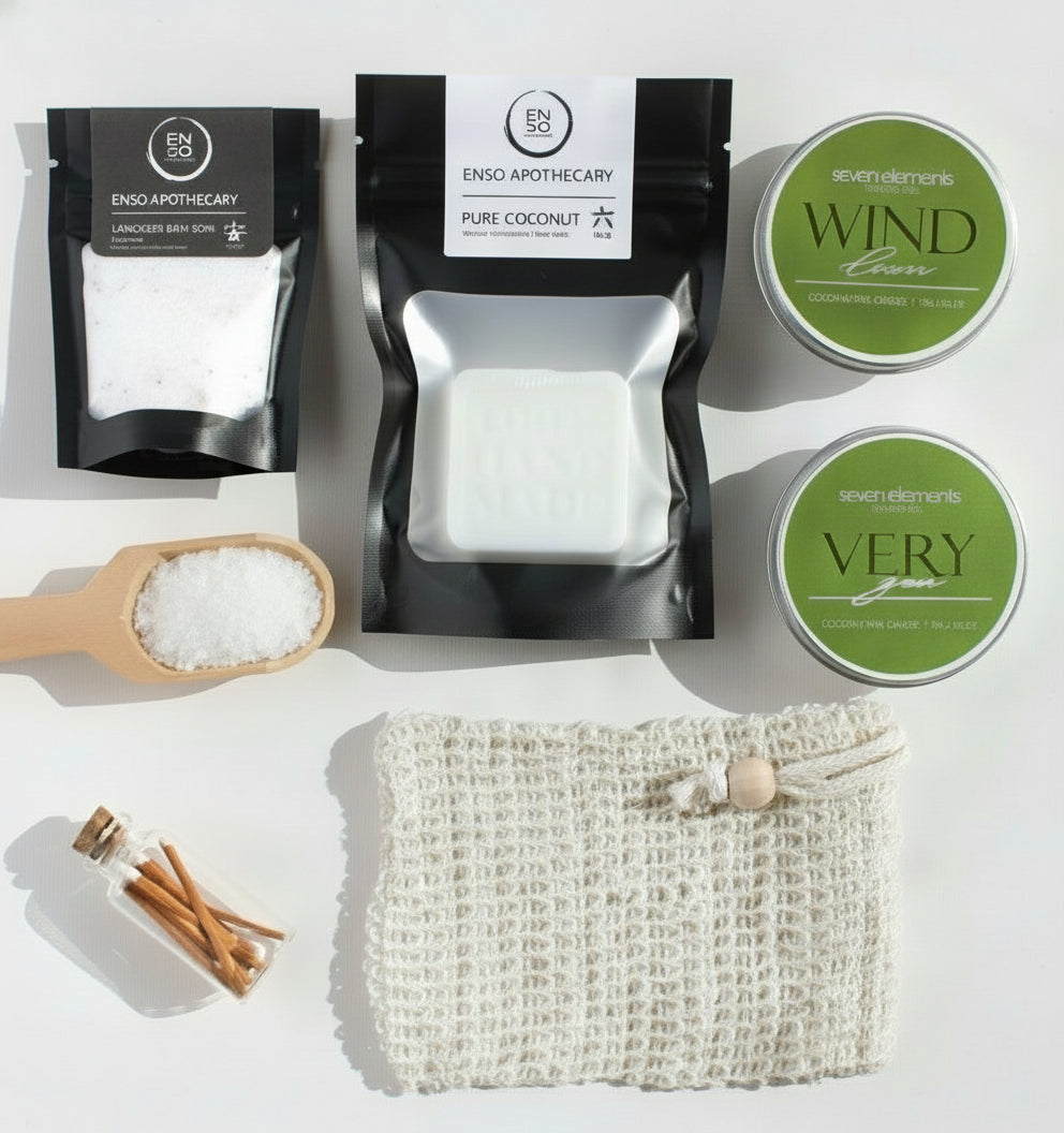 Collection of natural products including soap, bath salts, and a loofah on a white background.